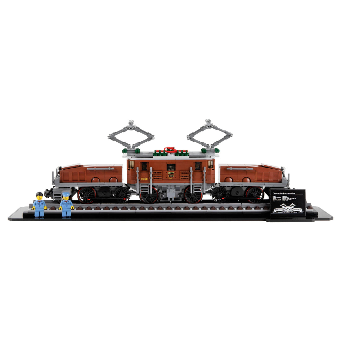 Brown LEGO Crocodile Locomotive 10277 displayed on a long track base with figures and a plaque