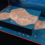 Close-up of the raised platform, stone-path print and minifigure locator studs in the LEGO 80121 display case.